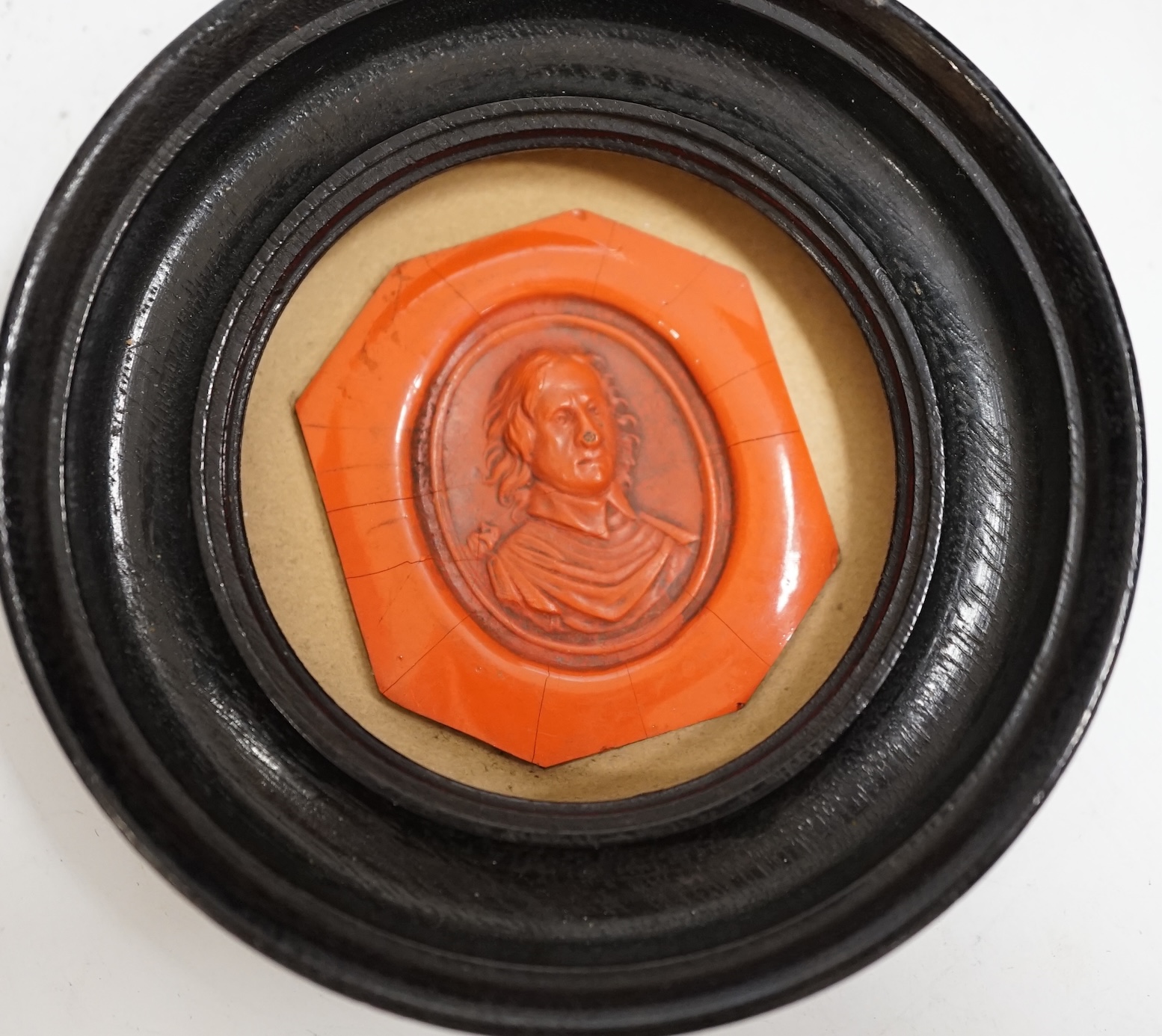 A framed red wax portrait of Oliver Cromwell, label verso reads ‘Oliver Cromwell the founder of English Liberty born 1599 died 1658 Emilie J. Bosignieu? 19-/68?’, 8.5cm diameter. Condition - fair